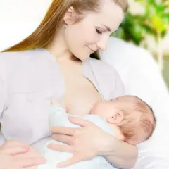 Kobieta karmi piersią dziecko. Wkrótce może pojawić się artykuł o tym, jak zatrzymać laktację.
