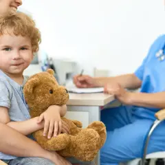 Mały chłopiec z misiem na wizycie u lekarza, martwiąc się o chrapanie u niemowlaka.