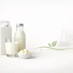Biały karton, szklana butelka i szklanka z mlekiem, miseczka z masłem. Idealne mleko UHT dla dzieci, pełne zdrowia i naturalności.