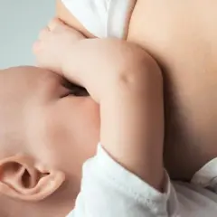 Delikatny moment karmienia piersią. Wkrótce przyjdzie czas, by dowiedzieć się, jak odstawić dziecko od piersi, ale teraz liczy się bliskość.