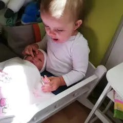 Starszy brat opiekuje się młodszym, który leży w łóżeczku. To piękny przykład skoku rozwojowego 18 miesiąc, gdy dzieci uczą się empatii.
