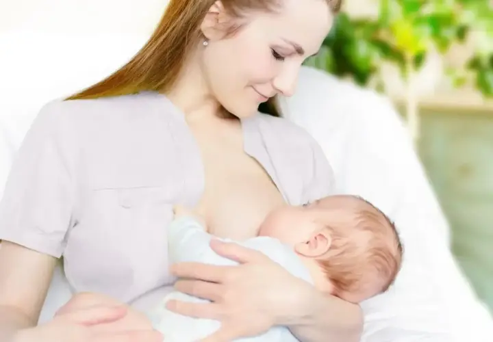 Kobieta karmi piersią dziecko. Wkrótce może pojawić się artykuł o tym, jak zatrzymać laktację.