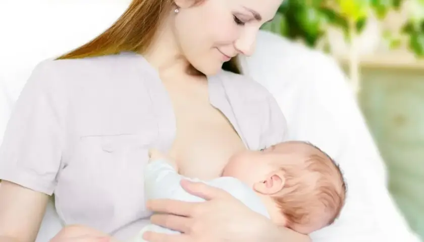 Kobieta karmi piersią dziecko. Wkrótce może pojawić się artykuł o tym, jak zatrzymać laktację.