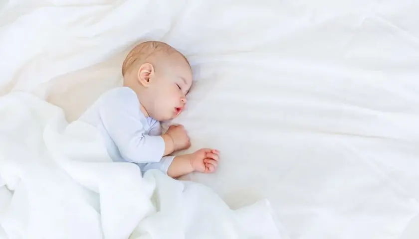 Słodki niemowlak śpi spokojnie. Ile powinno spac 10 miesieczne niemowle? Około 12-15 godzin na dobę, z drzemkami w ciągu dnia.