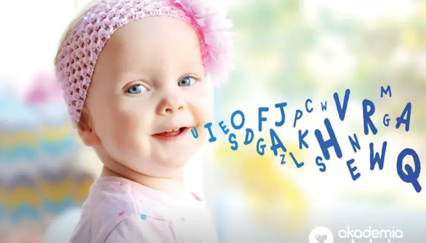 Uśmiechnięte dziecko z niebieskimi oczami, kiedy dziecko zaczyna mówić pierwsze zdania, a litery unoszą się z jego ust.