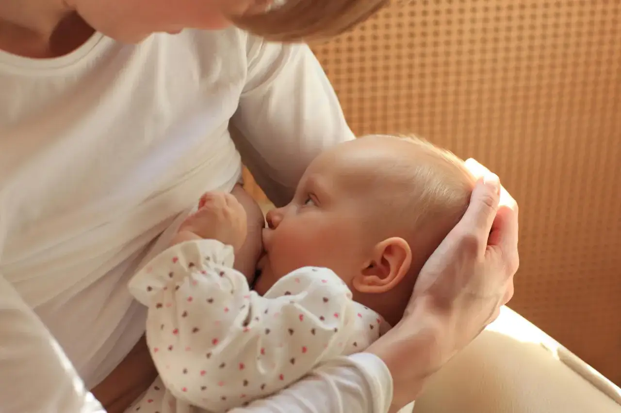 Mama karmi piersią dziecko. Ważne jest, by unikać palenia w ciąży i podczas karmienia piersią.